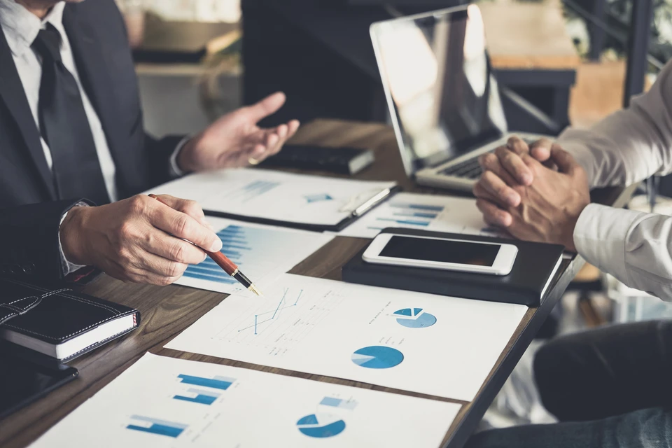 Réunion d'affaires en intérieur avec professionnels analysant des données financières